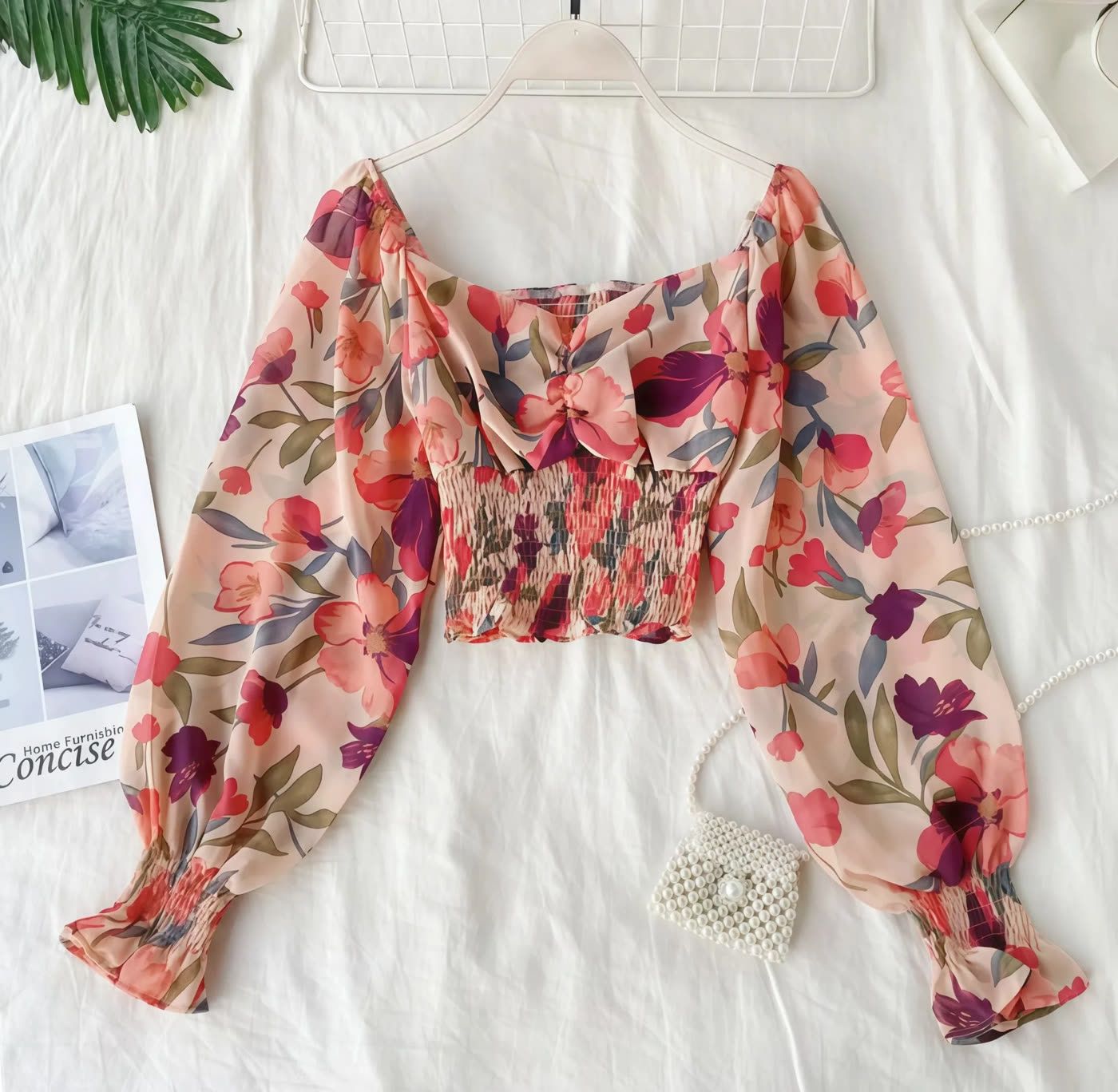 Floral chiffon top arranged as a flat lay on a white background