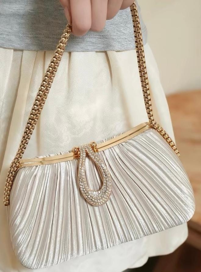 Silver pleated handbag with a gold chain and jeweled clasp