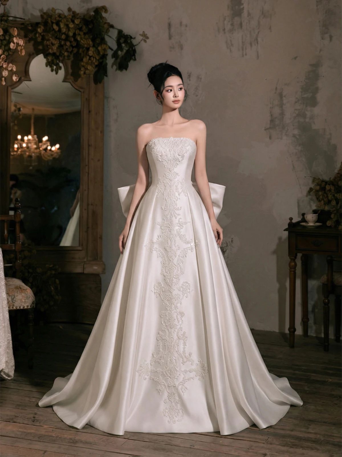 Model wearing a white bridal gown in a dim stone interior