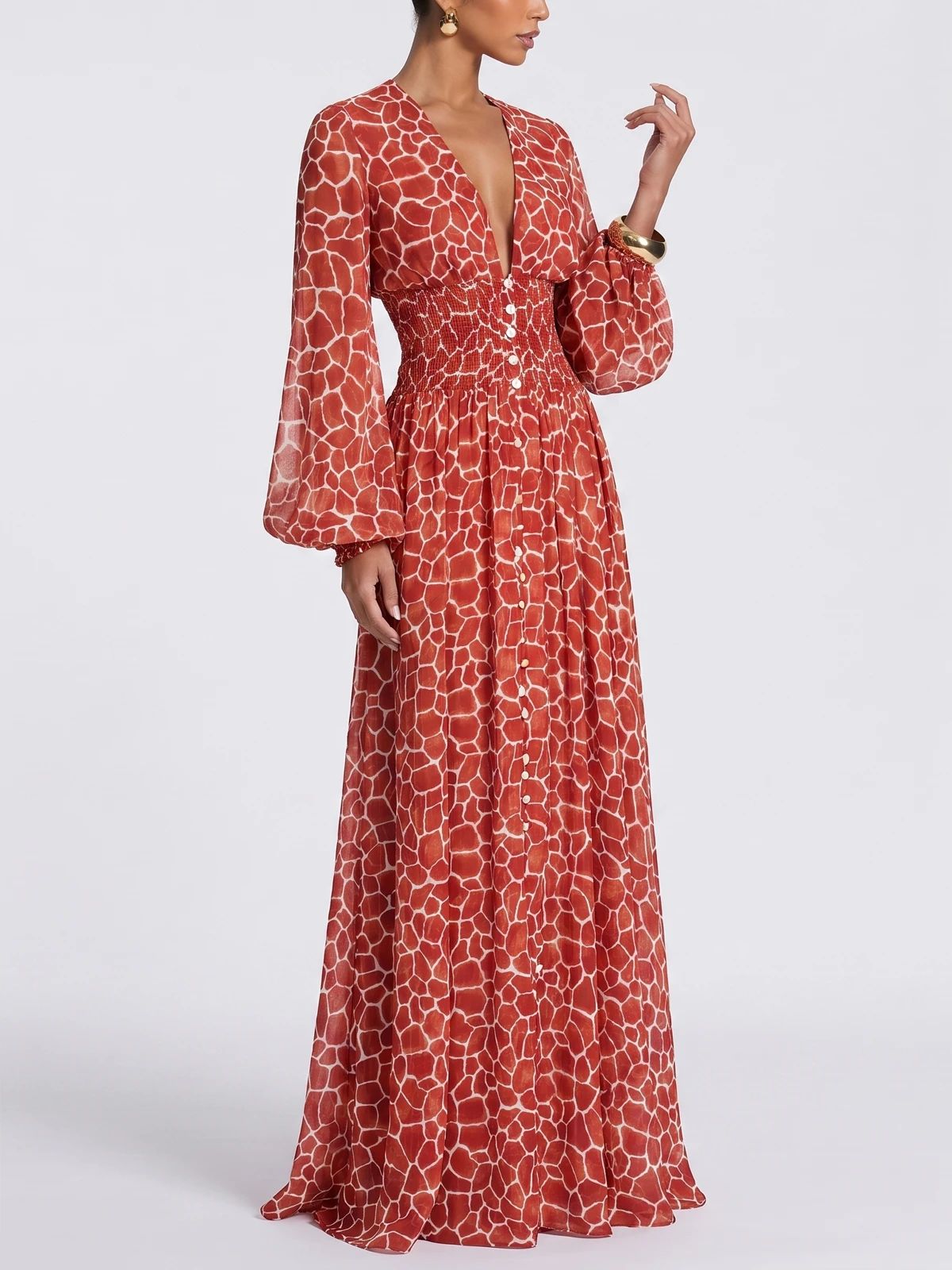 Model wearing a red floral-print maxi dress against a light studio backdrop