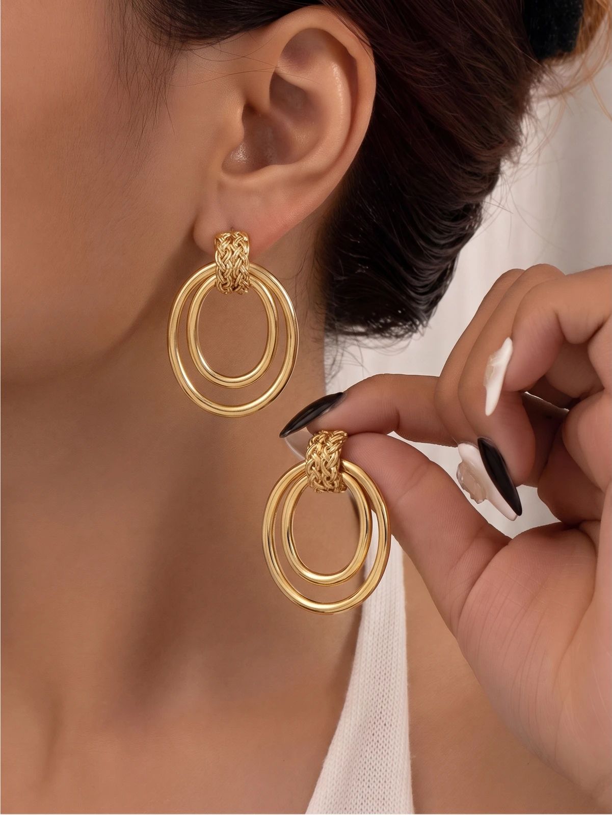 Model wearing gold hoop earrings with hair pulled back