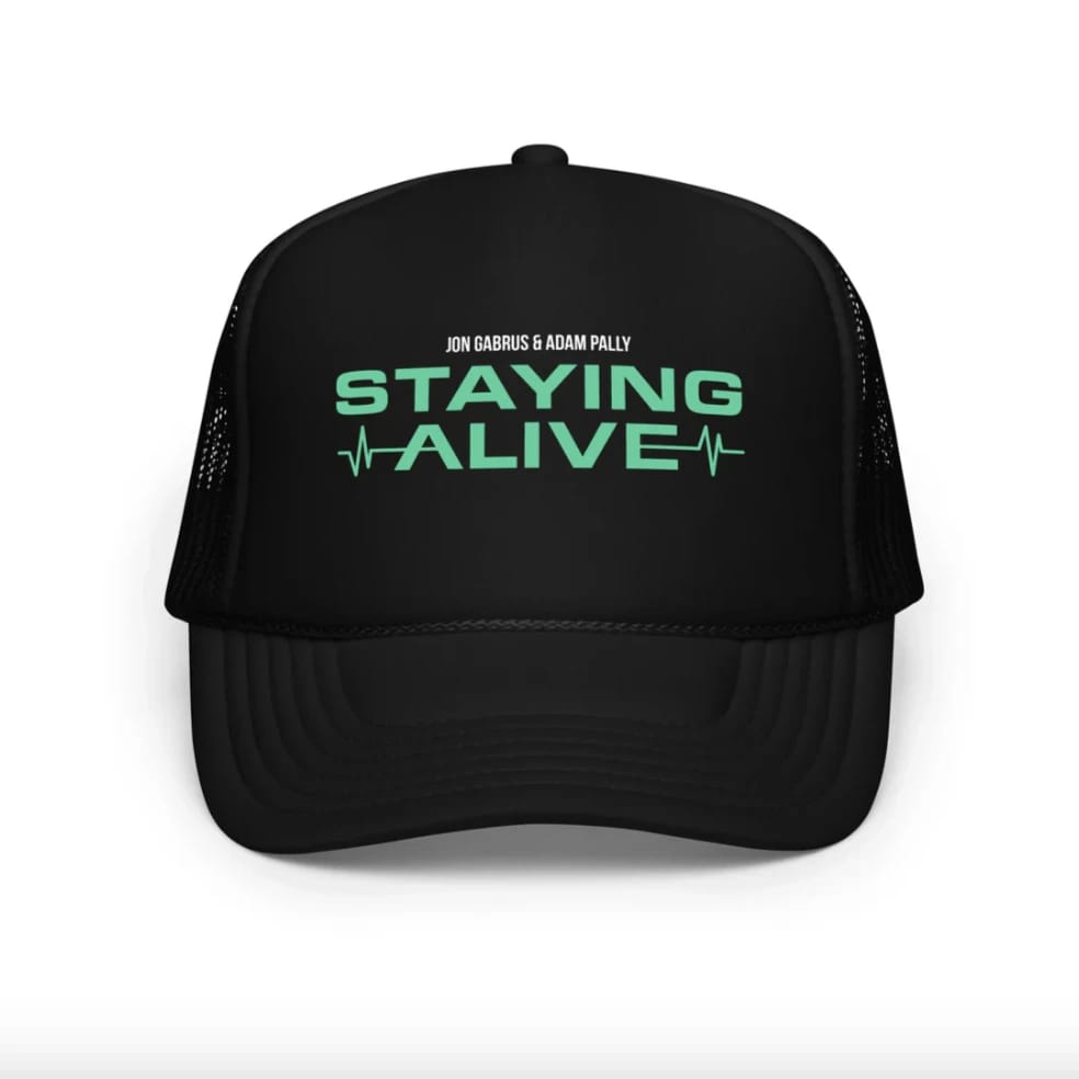 Black baseball cap with mint-green lettering on a white background