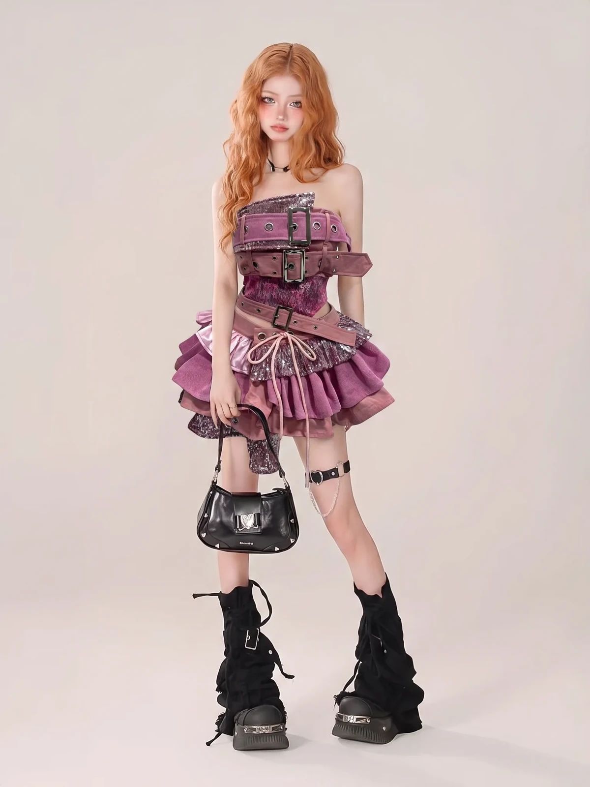 Model wearing a pink layered outfit with belts and chunky black boots