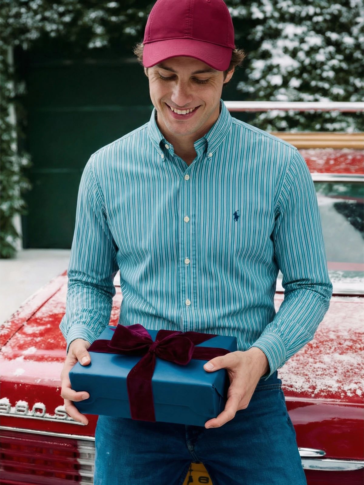 Man wearing a teal striped button-down shirt and red cap outdoors