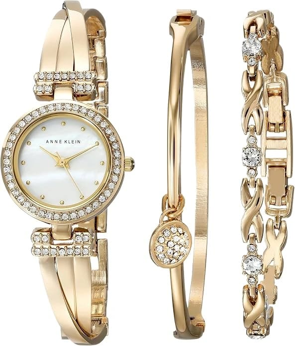 Gold wristwatch and matching bracelet arranged on a white background