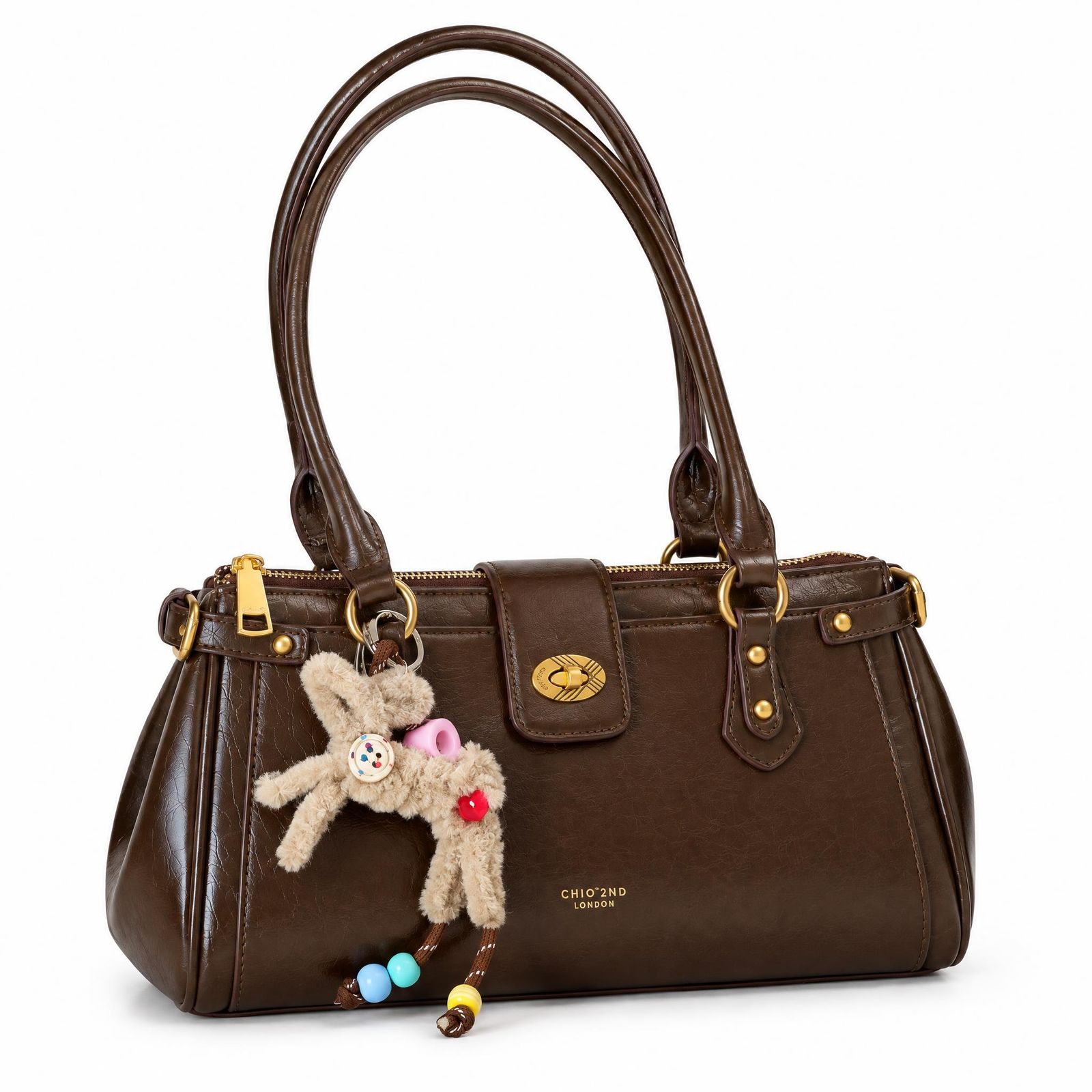 Brown leather handbag with a teddy-bear charm on a clean white background