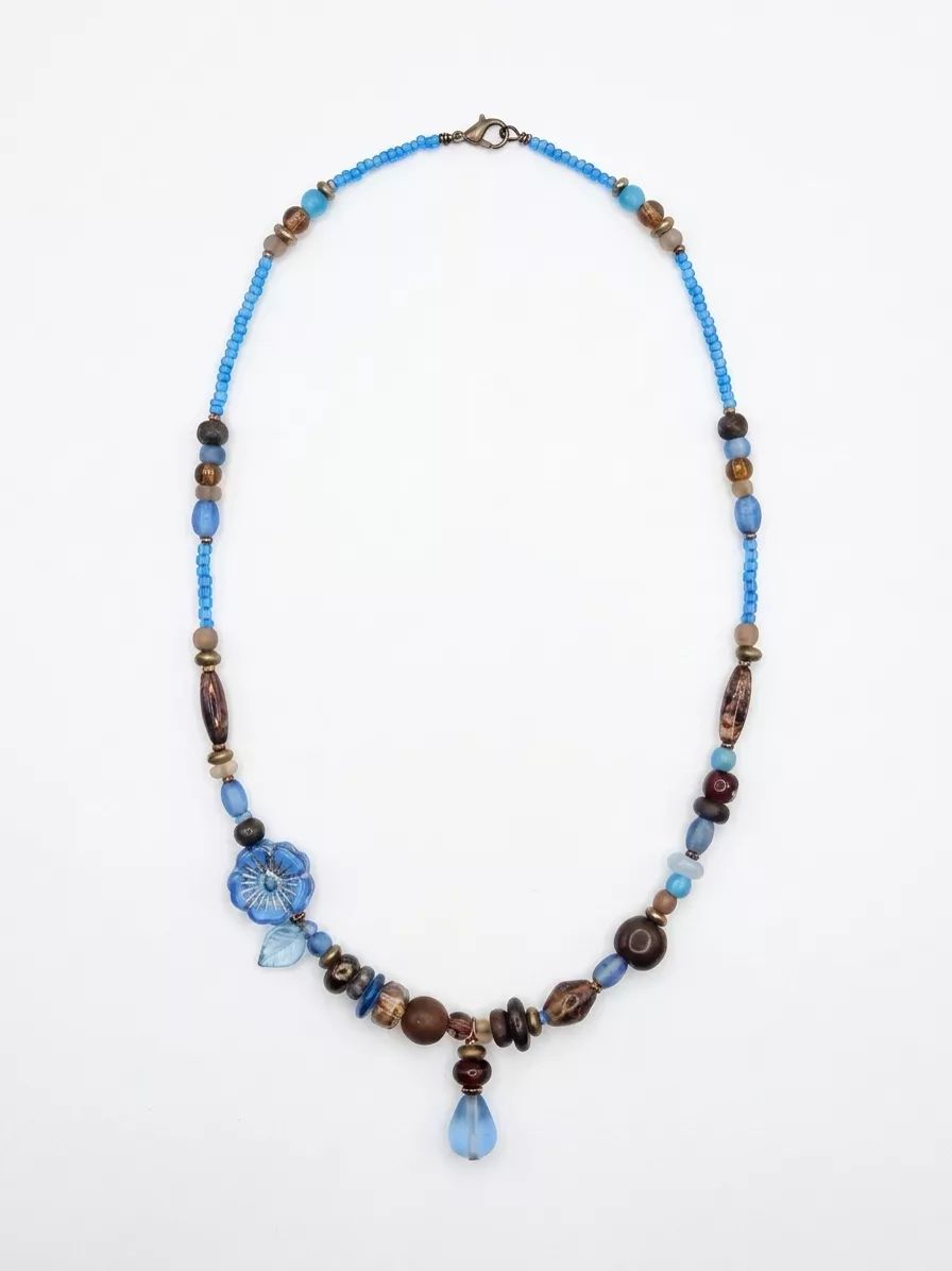 First AI attempt on the beaded necklace — flower bead repainted with different petals and the neighboring bead sequence changed