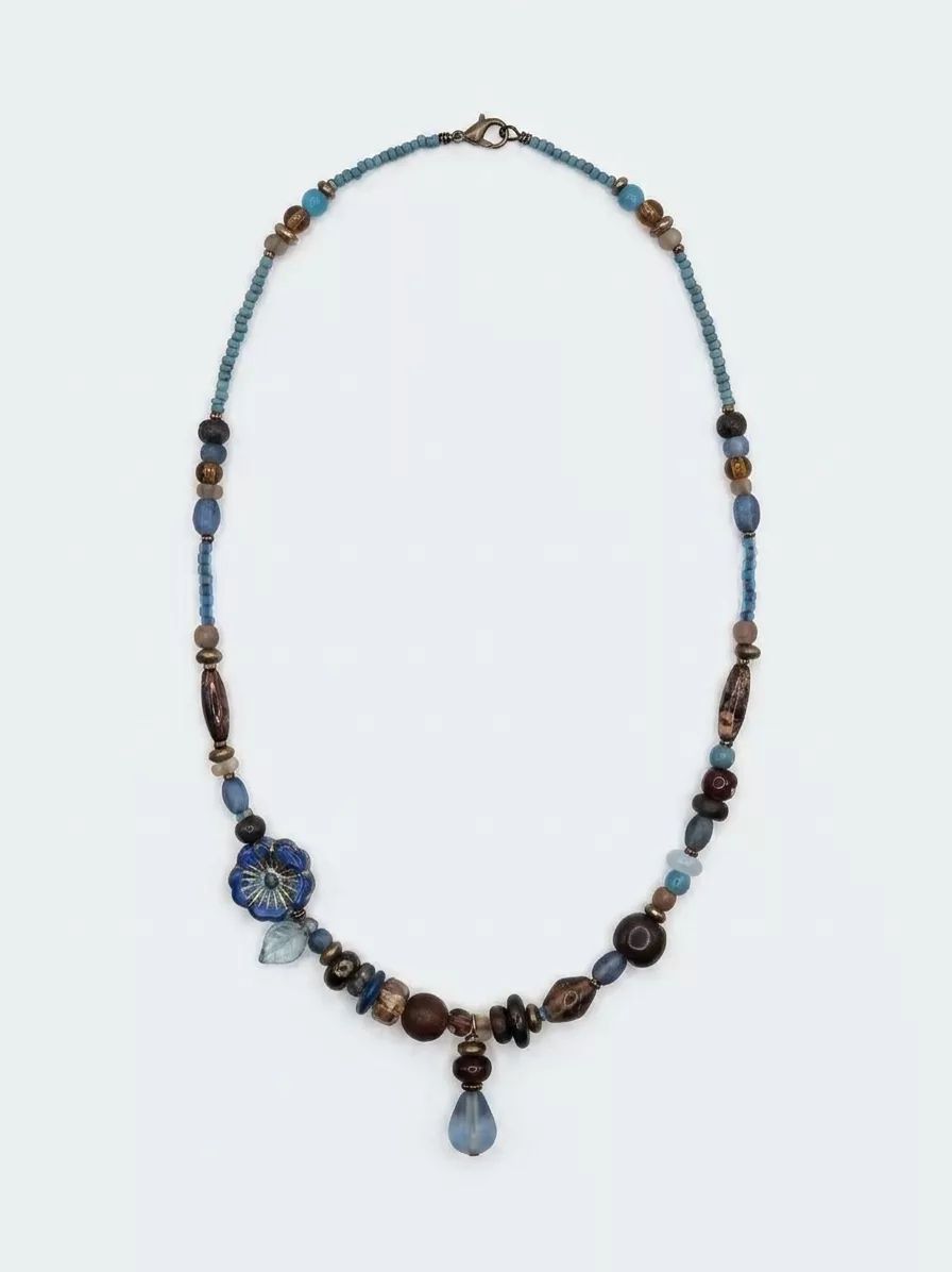 Second AI attempt on the beaded necklace — flower bead rendered differently again, beads reshuffled, inconsistent with both the source and the first attempt