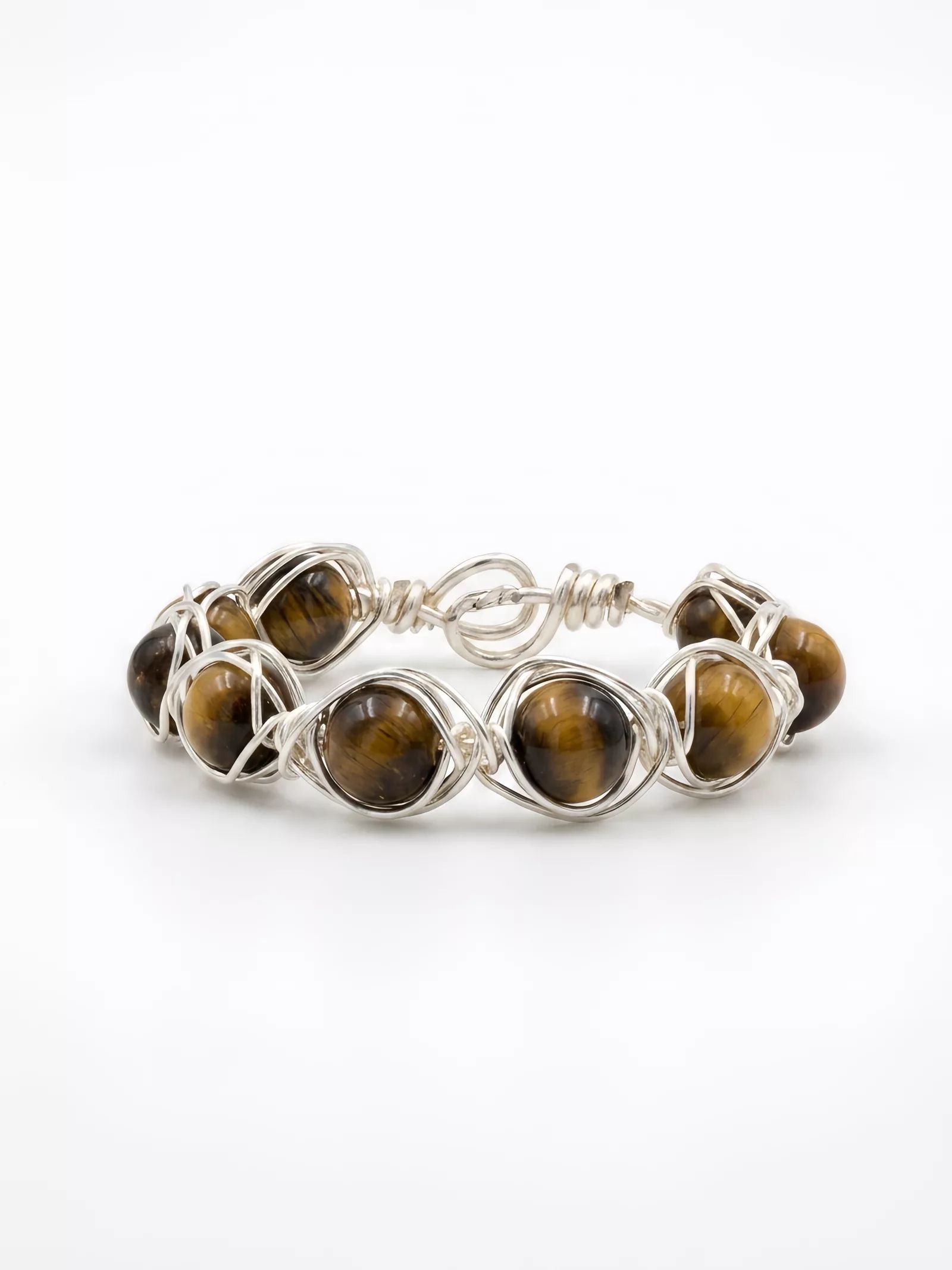 After Snappyit Jewelry Retouch — same tiger's eye ring on a clean white background with soft shadow, stone banding and wire texture preserved