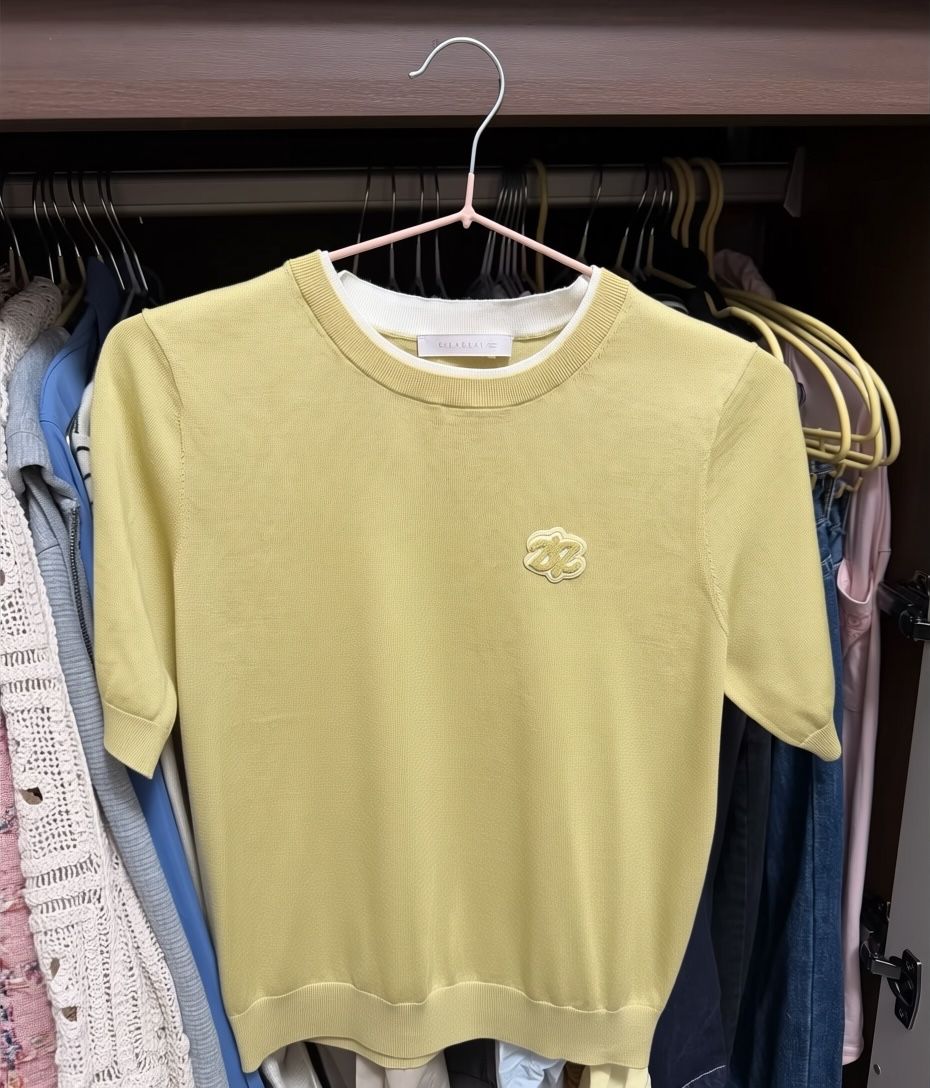 Yellow knit top with a chest motif after Photoroom wrinkle removal