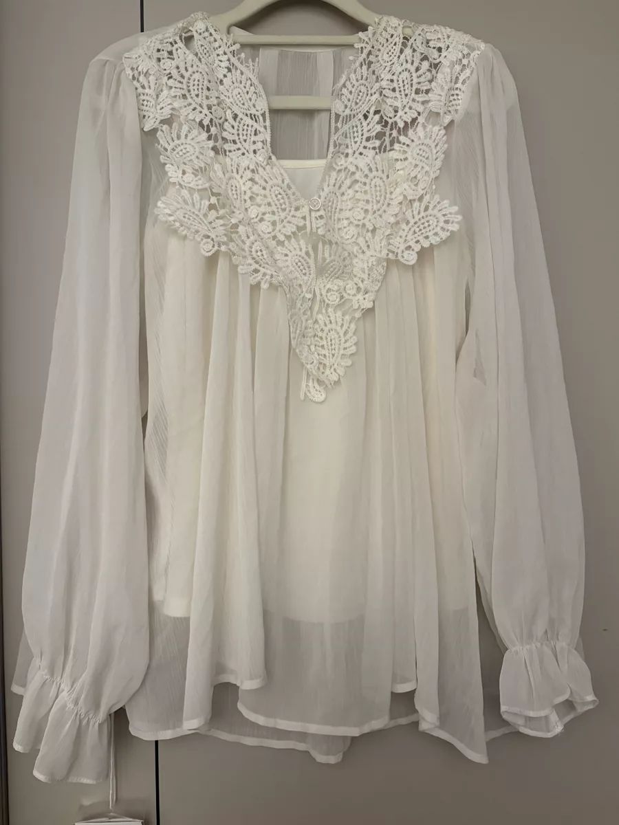 White lace blouse on a hanger before AI flat lay generation