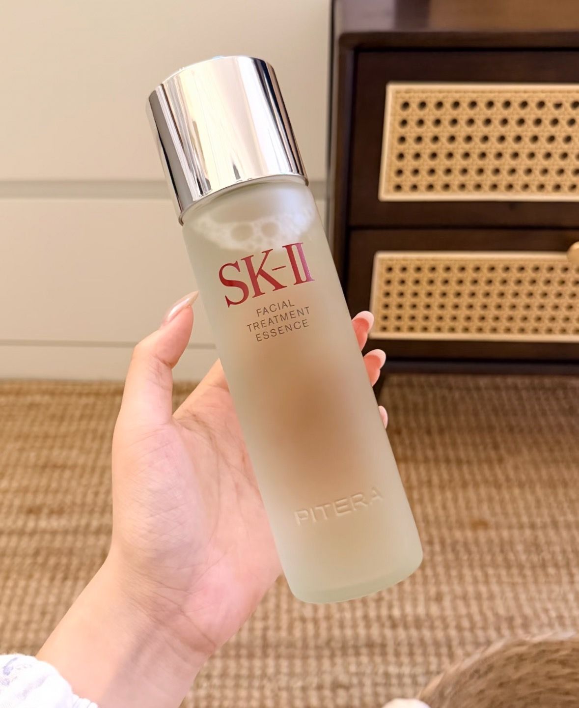 Cosmetic bottle held in a hand before scene generation