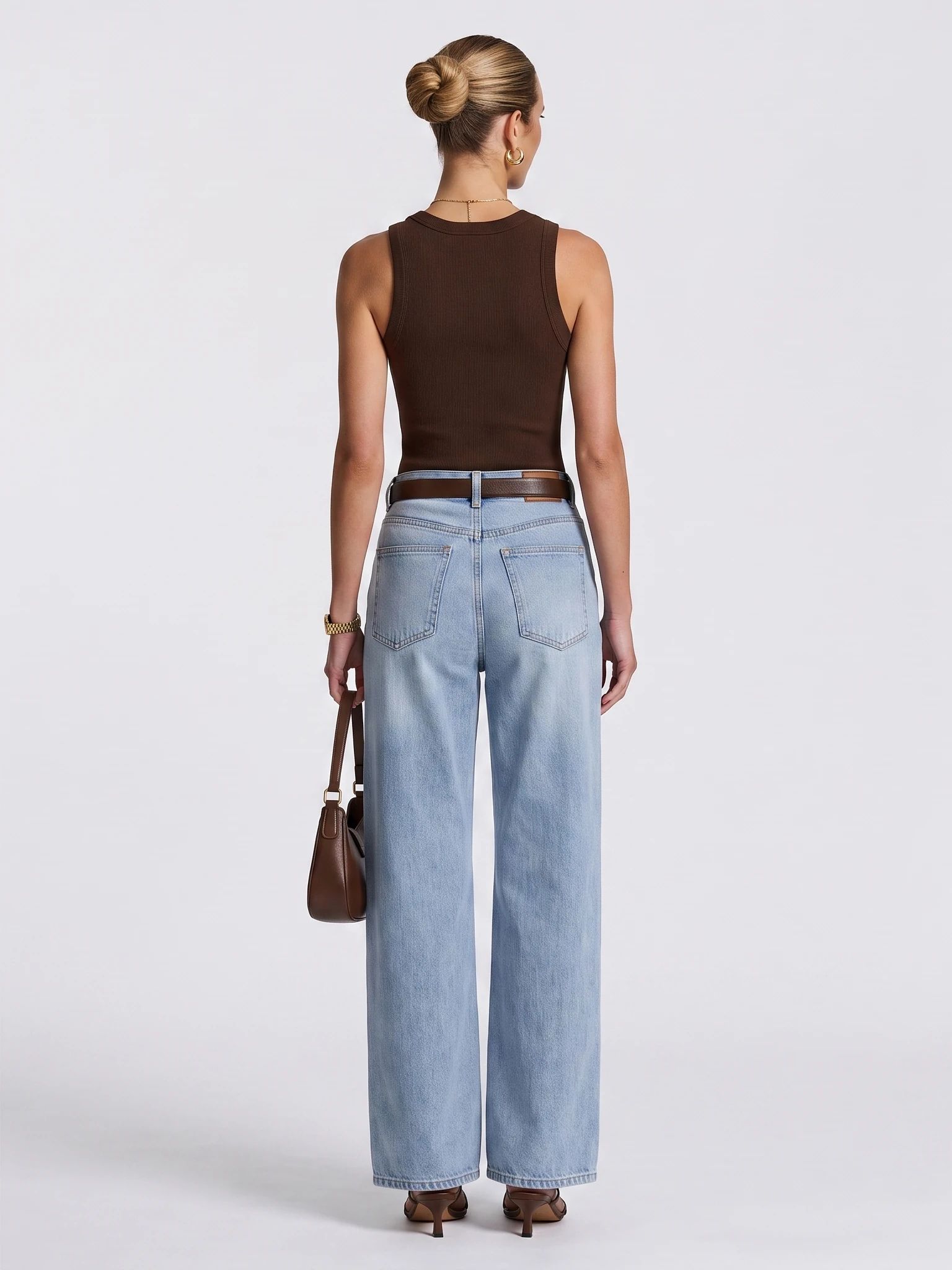 Full back view of a model wearing a brown sleeveless top and blue jeans, including the hems and shoes