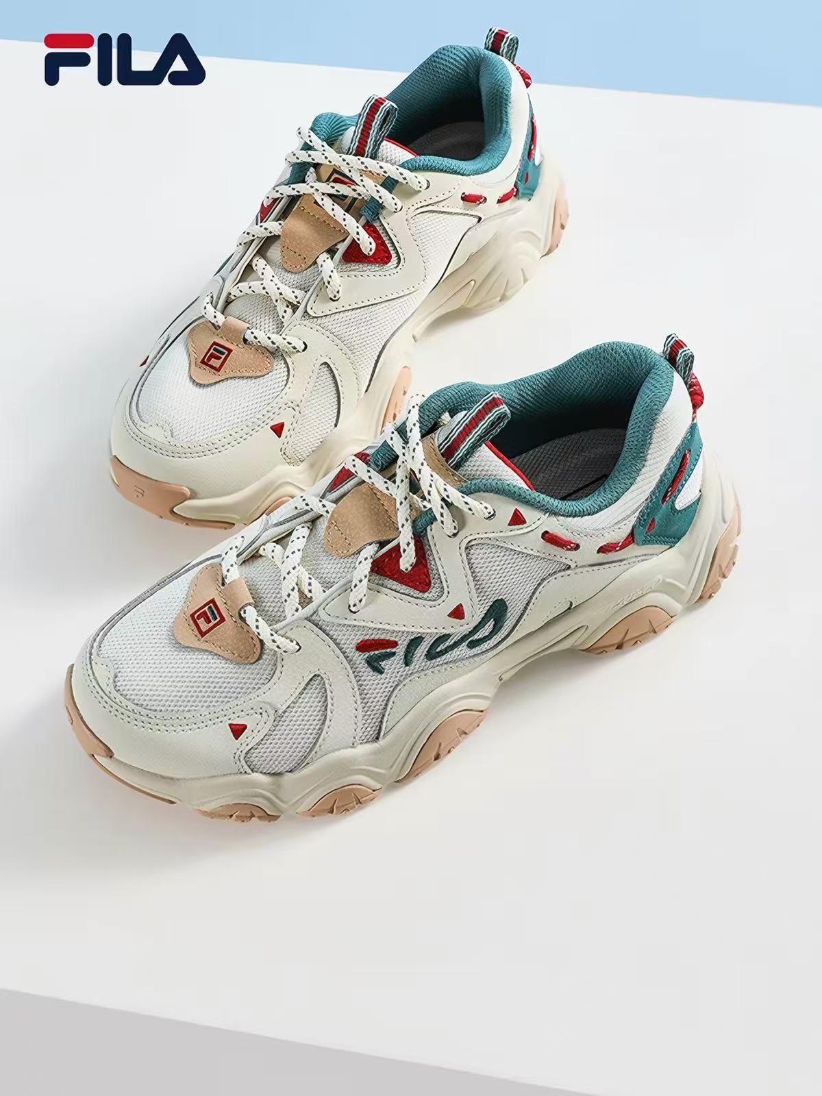 FILA chunky trainer in cream with teal and red trim and a tan gum sole, shot as a product packshot