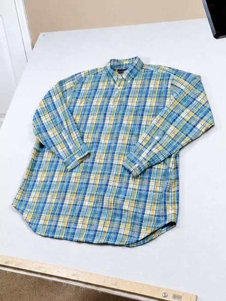 A blue-and-yellow plaid thrifted shirt photographed as a flat lay