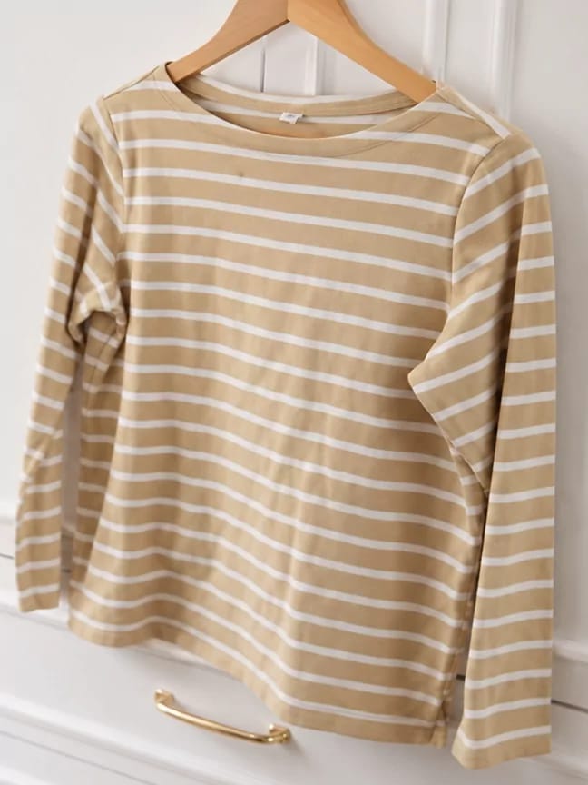 A beige striped thrifted top photographed on a hanger