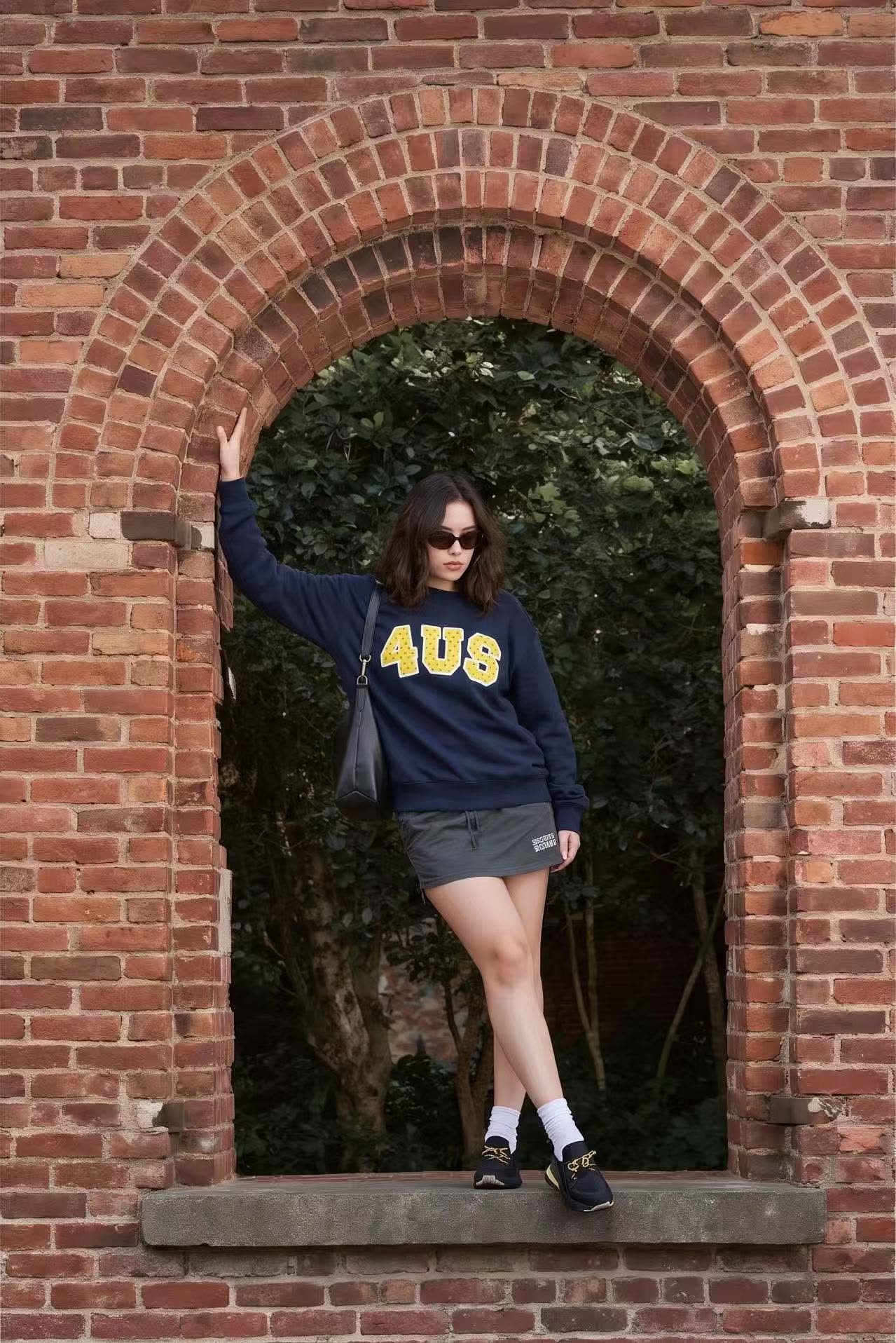 Navy printed sweatshirt on a model outdoors under a brick arch