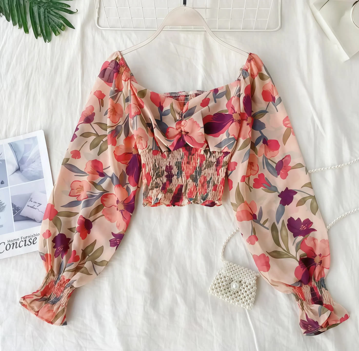 Floral chiffon top arranged as a flat lay on a white background