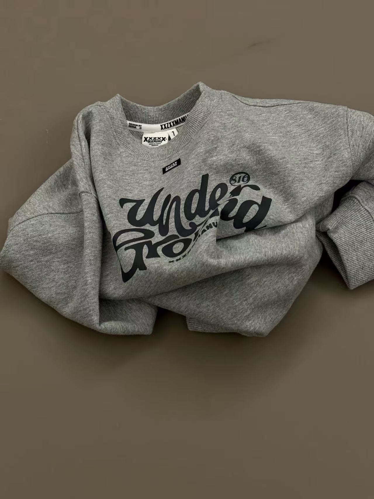 Folded printed sweatshirt with sleeves and part of the chest print hidden