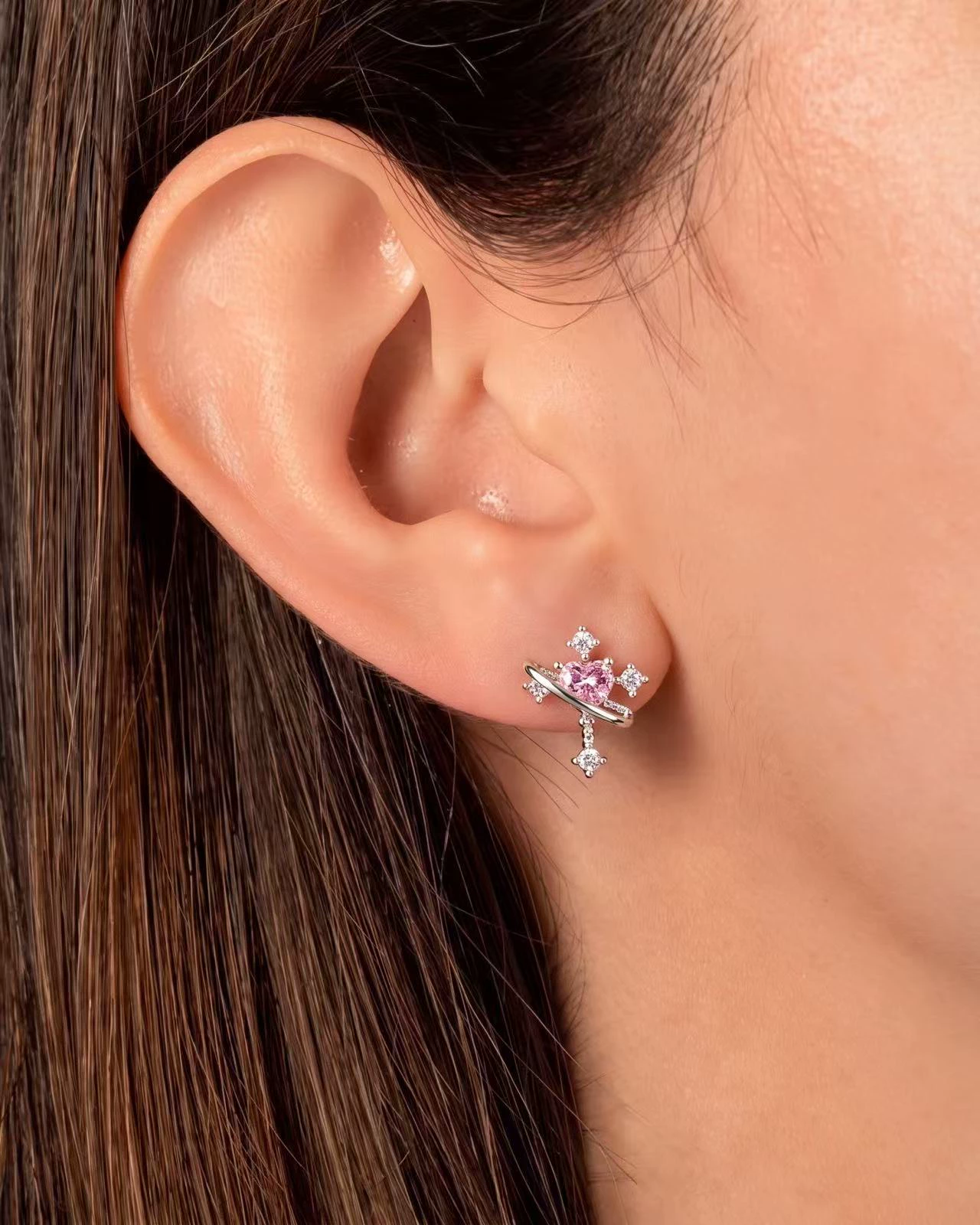 The pink heart stud on an AI-generated model, framed close on the ear