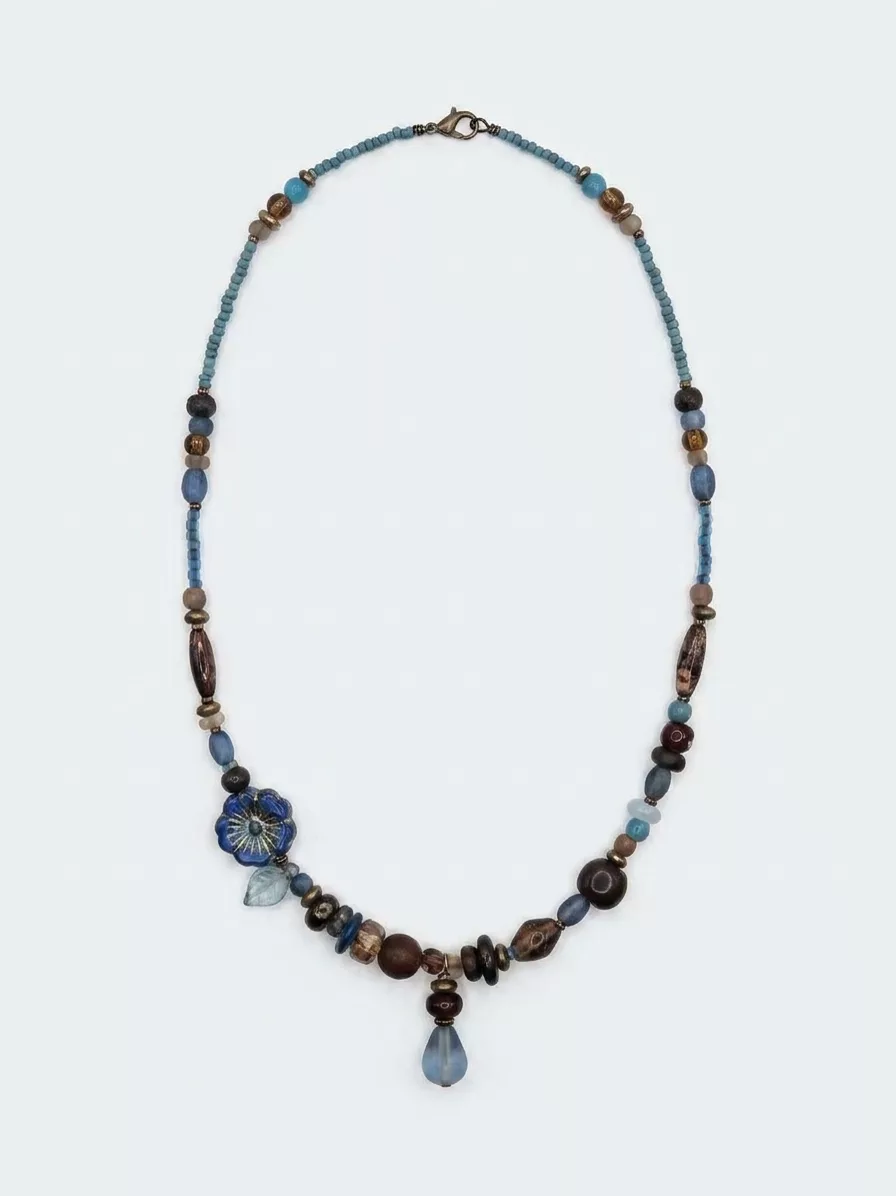 Second AI attempt on the beaded necklace — flower bead rendered differently again, beads reshuffled, inconsistent with both the source and the first attempt