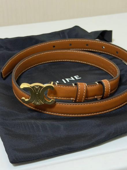 Flat-lay source photo of a slim leather belt with a gold buckle