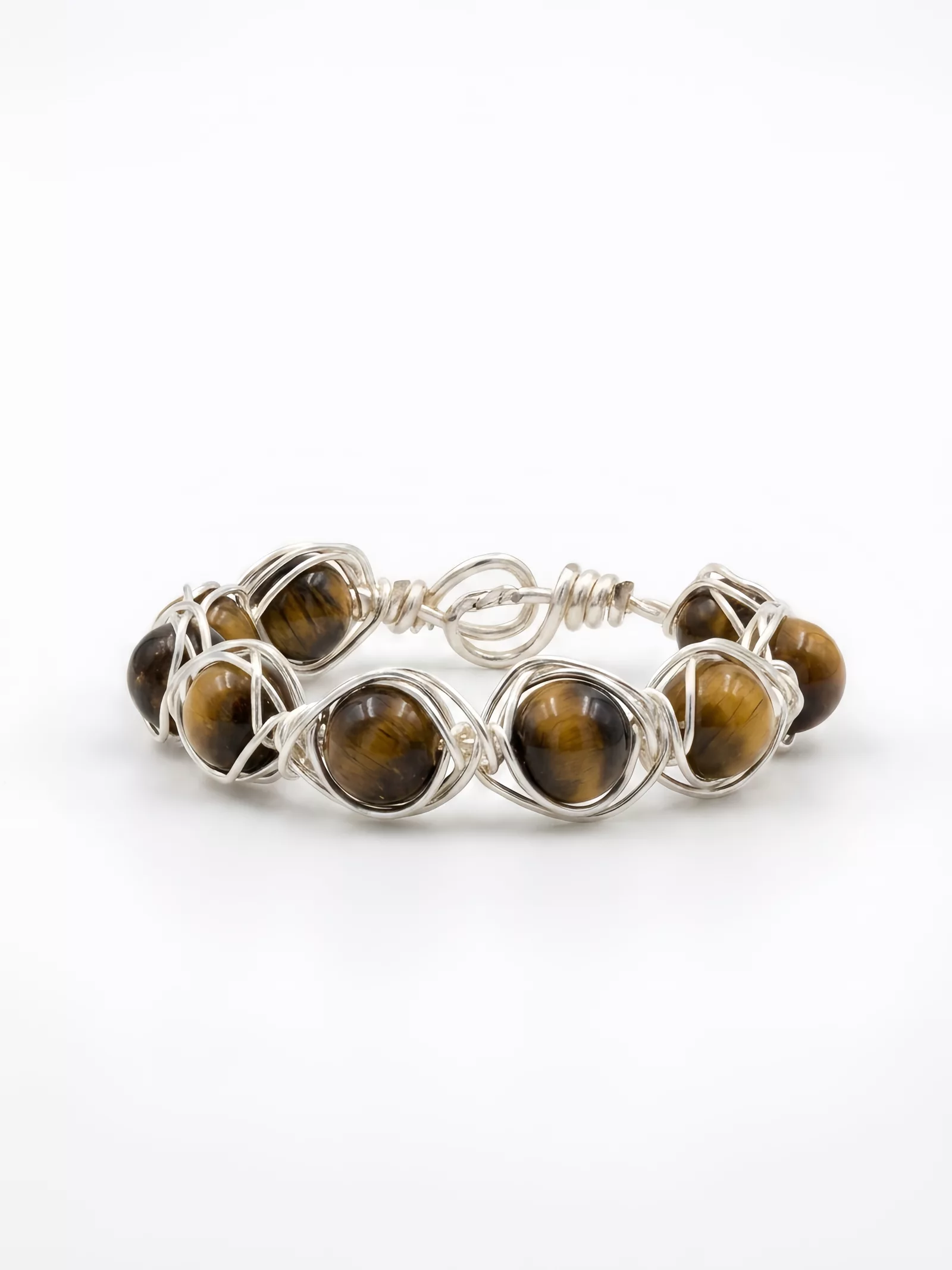 After Snappyit Jewelry Retouch — same tiger's eye ring on a clean white background with soft shadow, stone banding and wire texture preserved