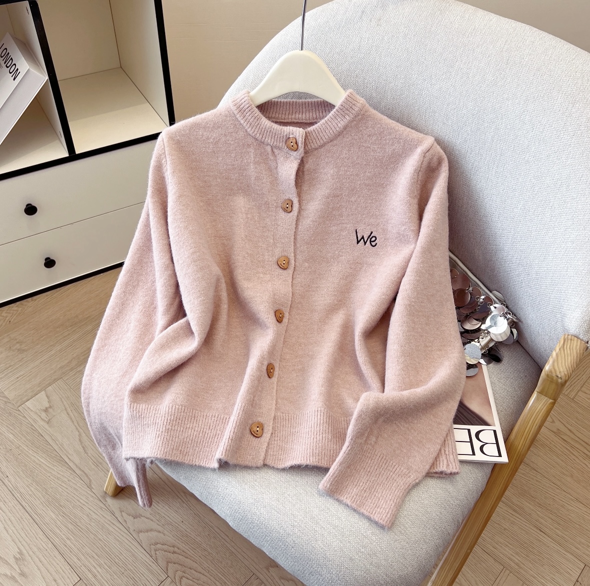 Phone source photo of a pink cardigan on a hanger
