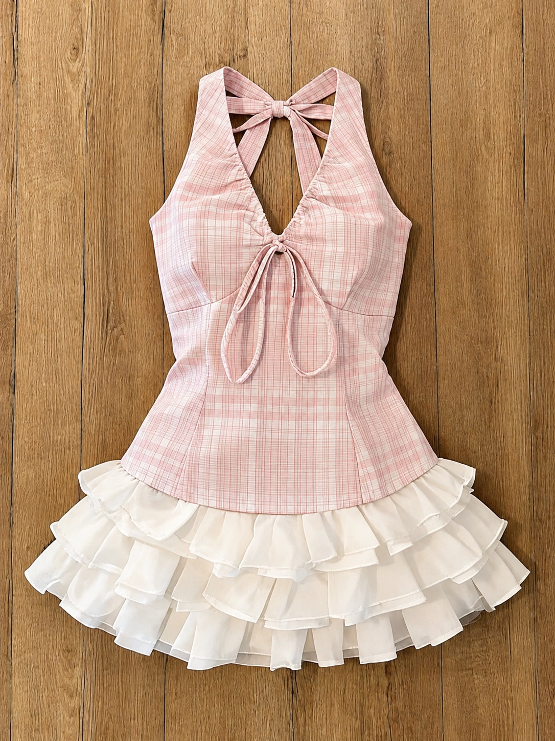 Original pink plaid top and white ruffled skirt on a wood floor
