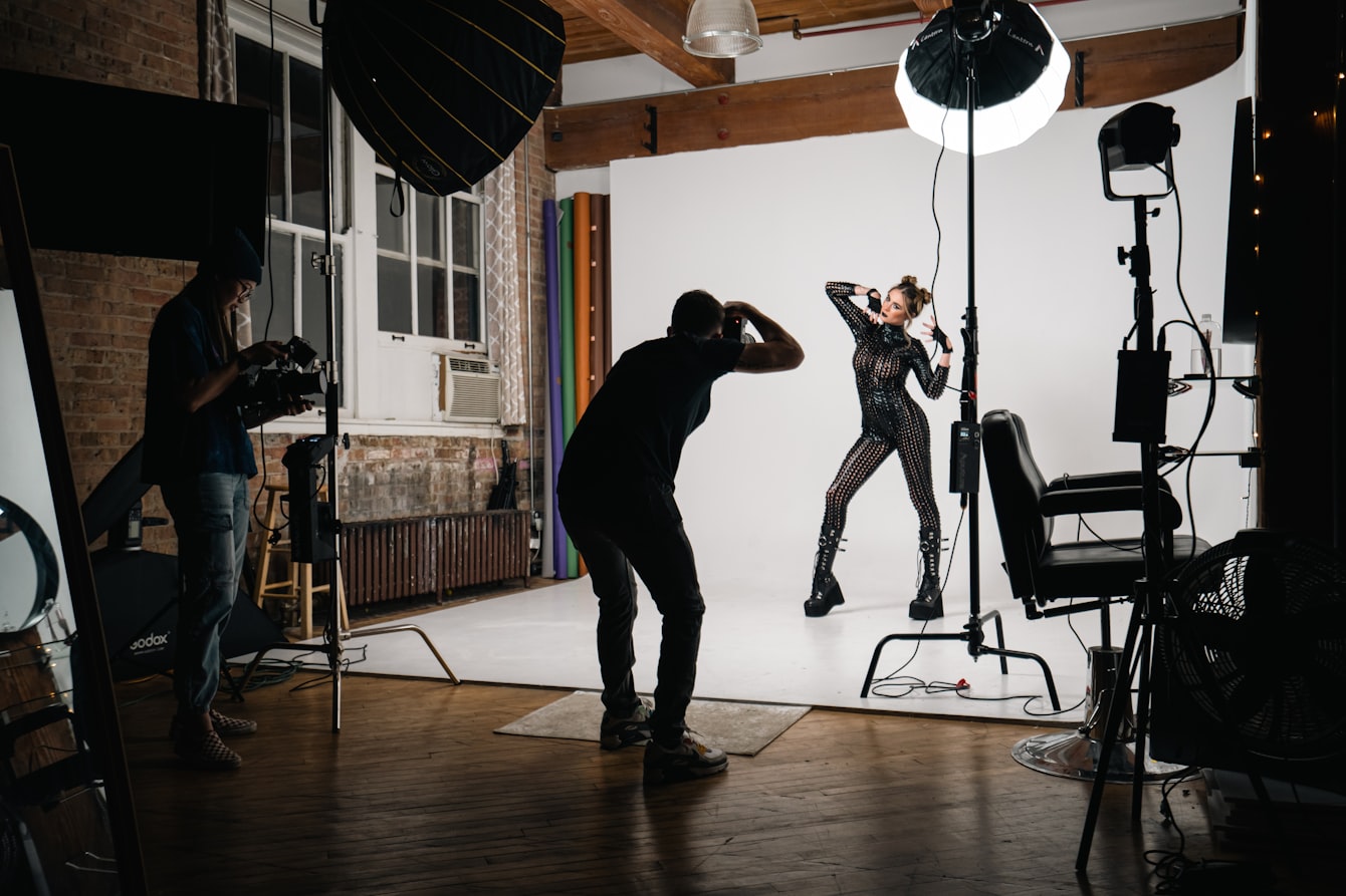 On-model clothing photography in progress — a photographer shooting a model wearing the garment in a studio