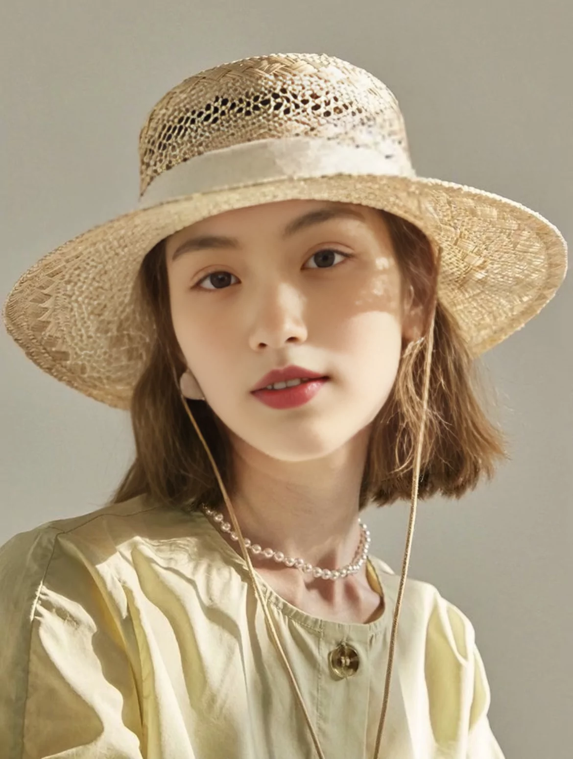 remaker ai face swap result from source face a with the original brown bob hairstyle retained and the dappled hat light preserved