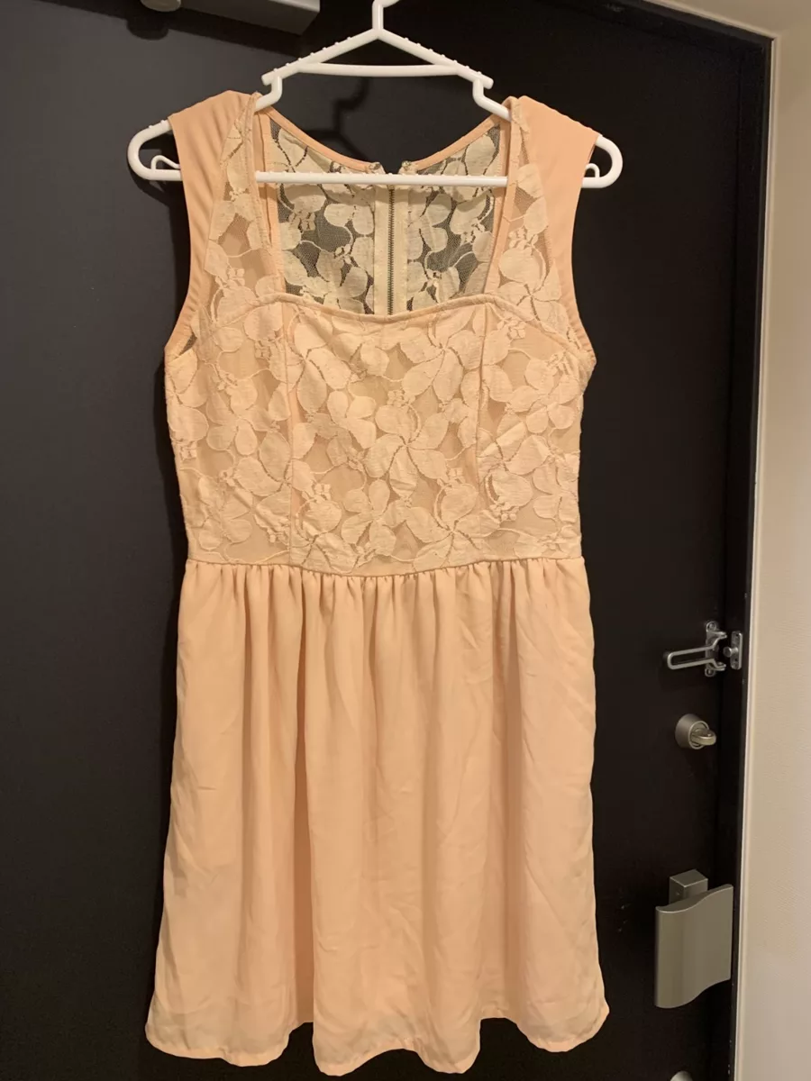 Peach lace dress hanging on a door before AI flat lay generation