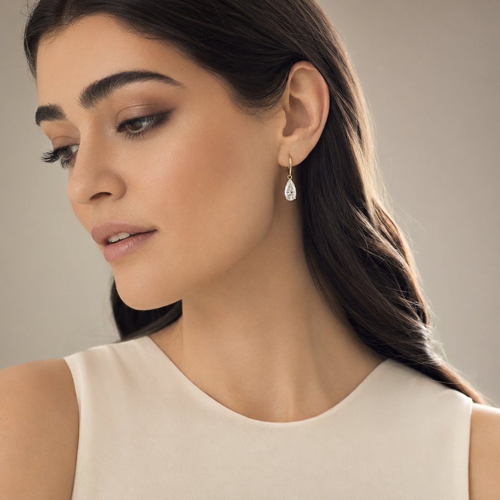 A three-quarter face turn with hair pulled back gives drop earrings full visibility and natural light interaction