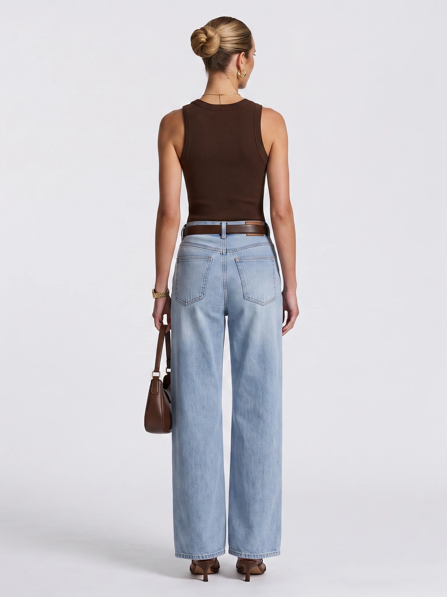 Full back view of a model wearing a brown sleeveless top and blue jeans, including the hems and shoes