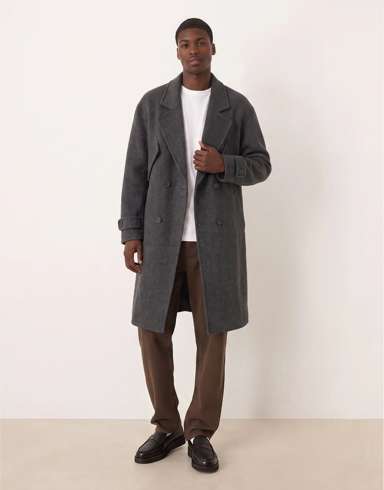 A gray coat worn open to reveal the shirt beneath it.