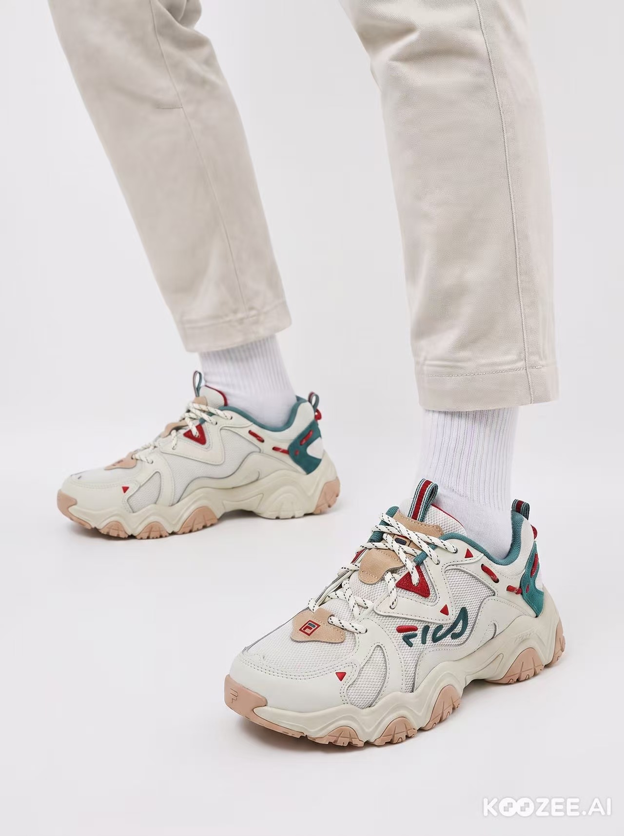 The FILA trainer worn on a model, cropped close to the feet and ankles against a white background