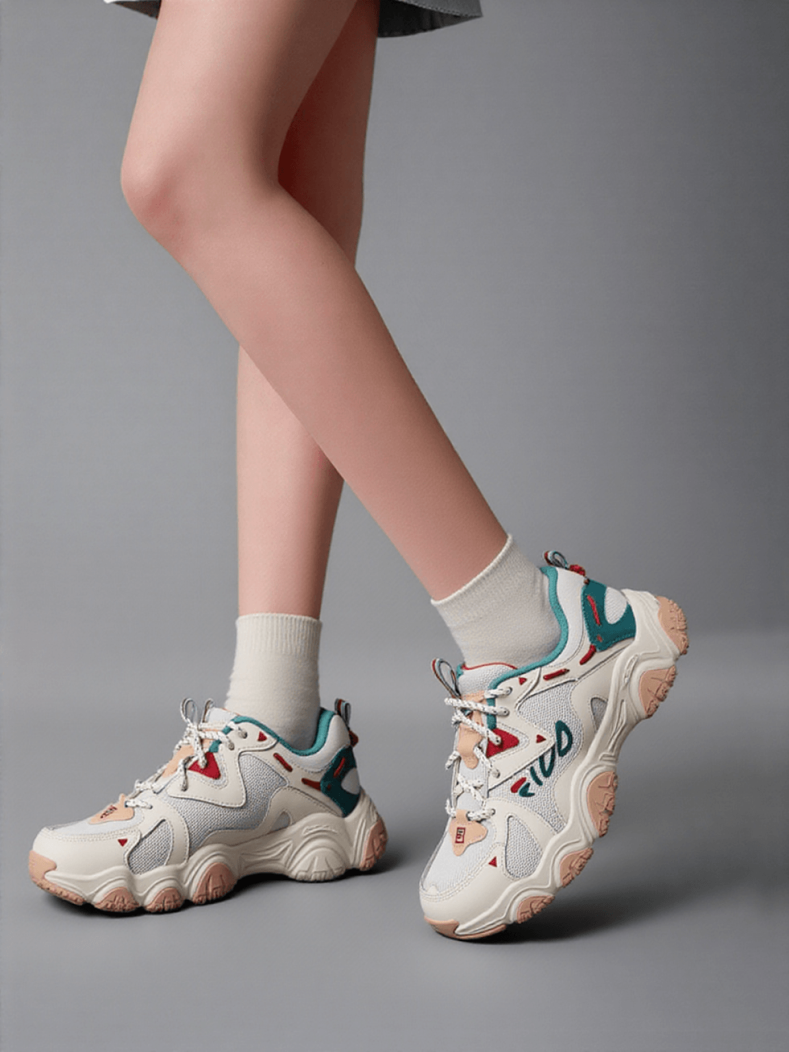 The FILA trainer worn by an AI-generated model, framed from the knees down in a grey studio