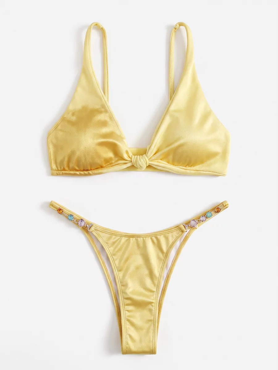 Yellow bikini shown as an AI-generated flat lay on a white background