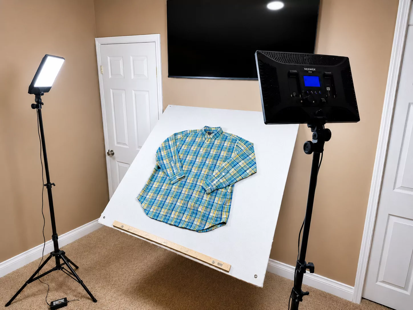 A thrifted shirt photographed on a flat-lay board with two professional LED panels