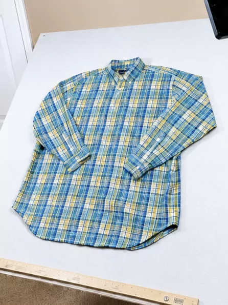 A blue-and-yellow plaid thrifted shirt photographed as a flat lay