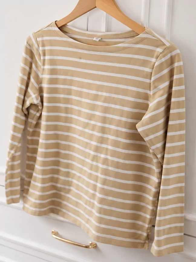 A beige striped thrifted top photographed on a hanger