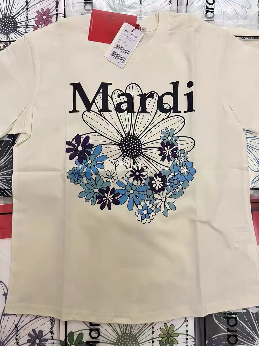 Source photo — cream Mardi Mercredi graphic tee shot on a phone with the hangtag still attached, used as the input for every tool tested