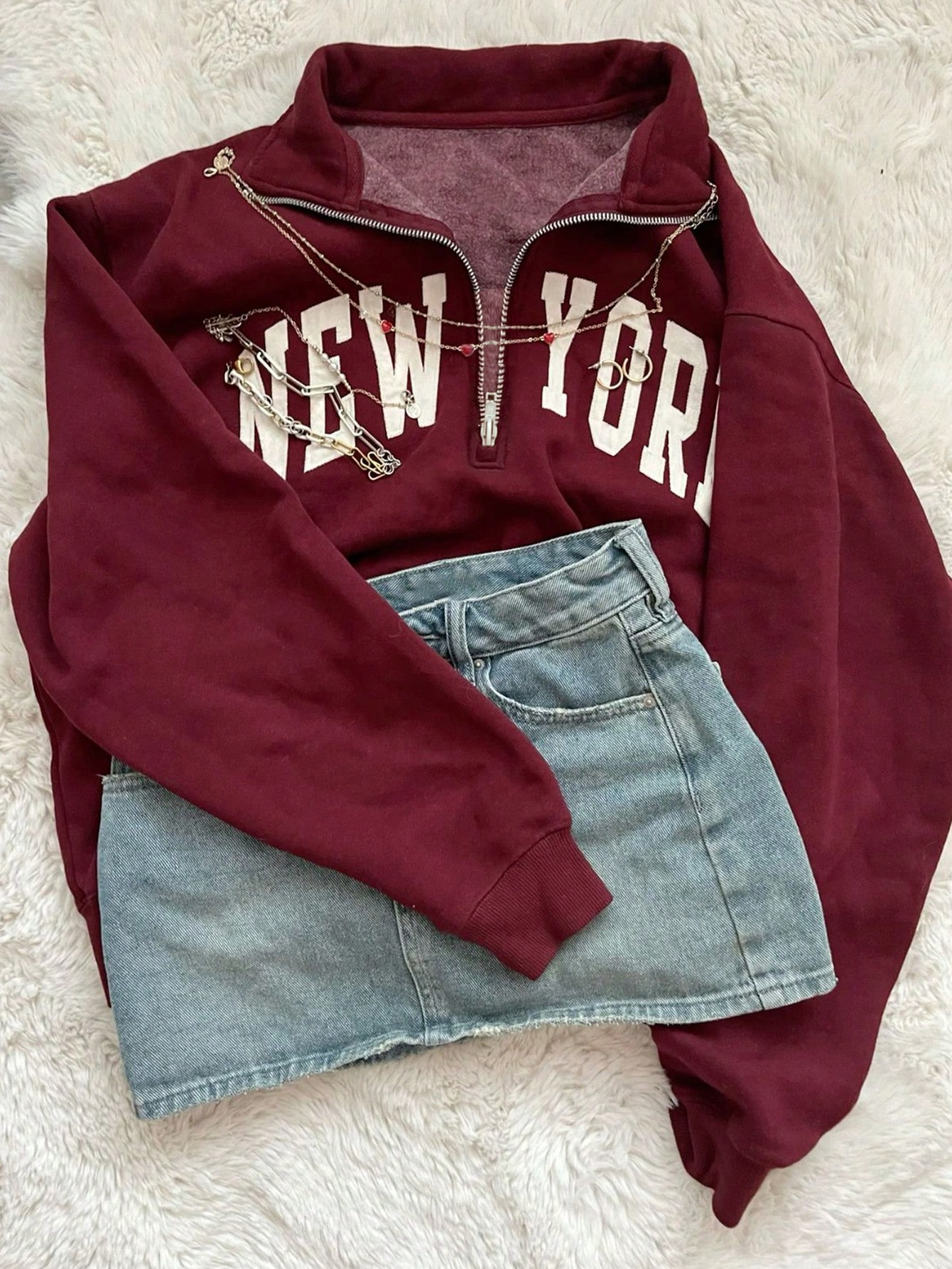 NEW YORK sweatshirt and denim mini skirt flat-lay with jewelry props — typical reseller styled phone shot